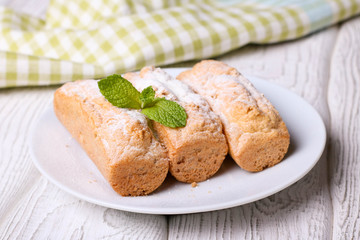 Eclairs with vanilla cream on a white plate