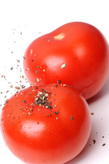 Ground Pepper Falling on Tomatoes