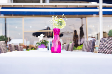 Decoration of fresh flowers on the table in outdoor restaurant