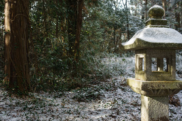 京都、古い神社の石灯籠と雪景色