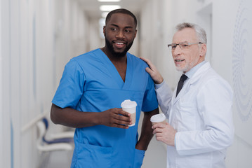 Fototapeta premium Easygoing aged practitioner enjoying conversation with young colleague at work