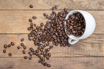 Coffee beans in coffee cup  on wooden background