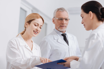 Delighted medics reading information about the patient in the clinic