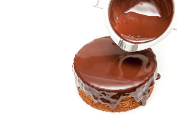 Pouring chocolate ganache to the cake pound on white background isolated with copy space