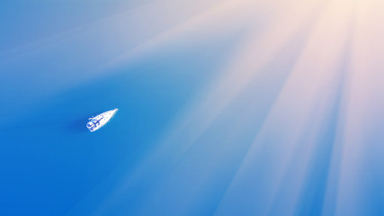 Fototapeta na wymiar White yacht in the blue sea in the sunlight, top view