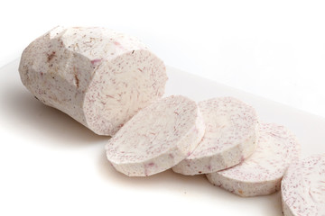 Sliced raw taro on white cutting board