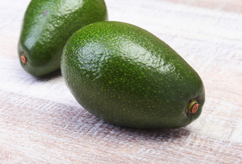 Fresh, green Avocado isolated on wooden background.