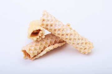 Homemade wafer rolls with powdered sugar isolated on white background