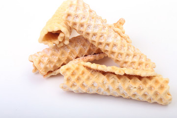 Homemade wafer rolls with powdered sugar isolated on white background