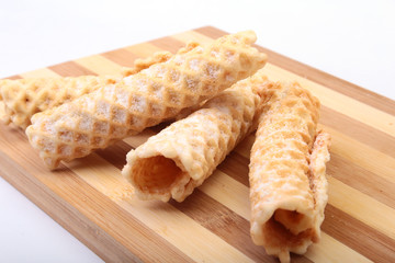 Homemade wafer rolls with powdered sugar isolated on white background