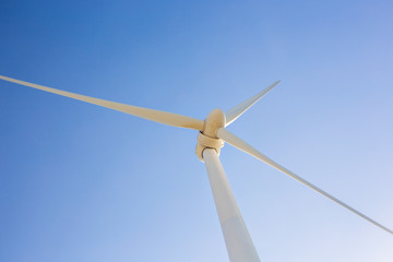 Fototapeta premium Wind turbine generating electricity with blue sky - energy conservation concept