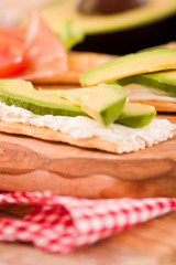 Crackers with ham and avocado. 