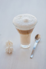 A large cappuccino in a transparent glass