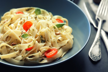 Plate with delicious pasta on table