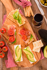 Crackers with ham and avocado. 