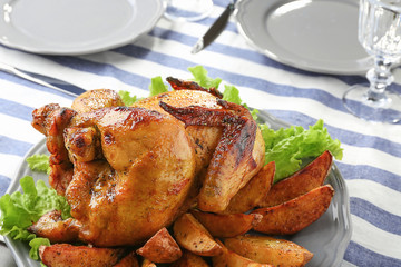 Plate with roasted beer can chicken on table