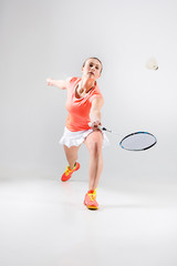 Fototapeta na wymiar Young woman playing badminton over white background
