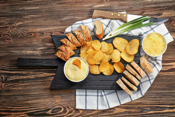 Bowl with beer cheese dip and chips on wooden board
