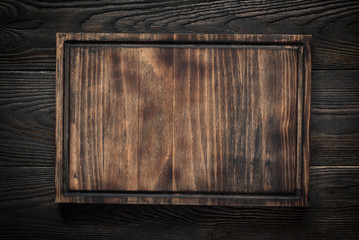 Cutting board on dark wooden table.