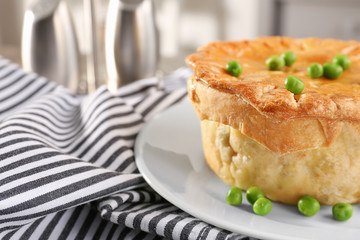 Tasty chicken pot pie with green peas on napkin