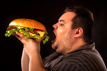 Diet failure of fat man eating fast food hamberger. Breakfast for overweight person who spoiled healthy food by eating huge hamburger. Junk meal leads to obesity. Person regularly overeats concept . - 144809628
