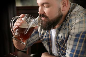 Bearded man drinking beer in pub