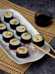 Sushi on white plate, grey background. Traditional Asian food. Diet healthy food. Selective focus. Space for text