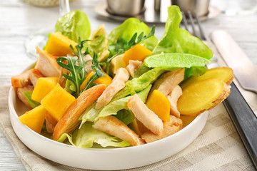 Plate with chicken salad on table