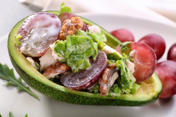 Plate with chicken salad in boat from avocado, closeup