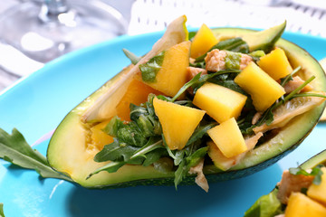 Plate with chicken salad in boat from avocado, closeup