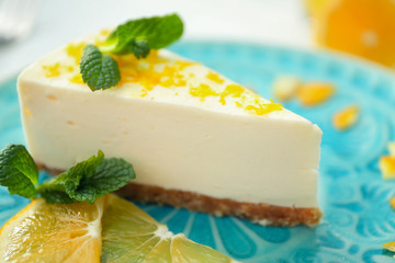 Tasty cheesecake slice with lemons on plate