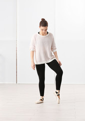 Fototapeta premium Ballet art concept. Young beautiful ballerina training in dance hall