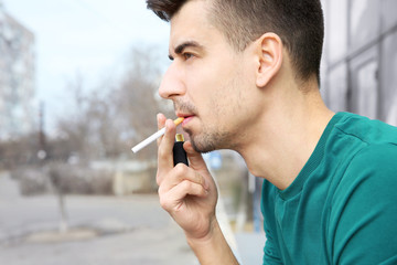 Young man smoking cigarette outdoors