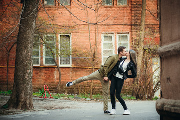 Couple has fun and laughs. kiss. Young hipster couple hugging each other in city.