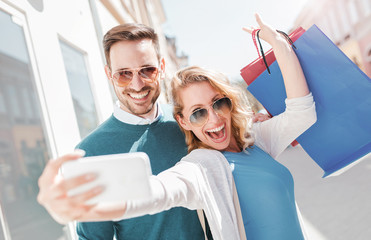 Beautiful young couple enjoying in shopping. Consumerism, fashion, lifestyle concept