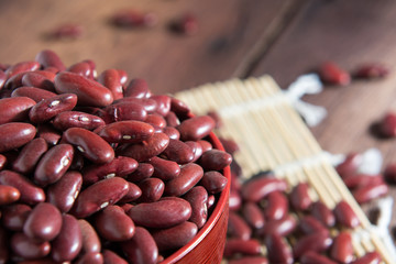 Red beans in a cup with a wooden sign on the wooden floor.