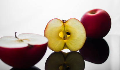 fresh red apple with droplets of water against black background reflection drops fresh splash action movement