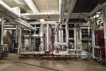 Fototapeta na wymiar Old heating system pipes in house cellar underground