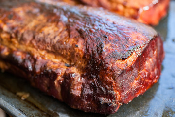 Close-up of freshly hot smoked, boneless pork chops or cutlets cooling on tray.