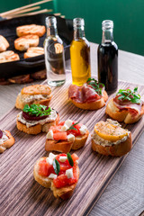 Set of bruschetta on wooden background  near bottle with sauce. Crostini.