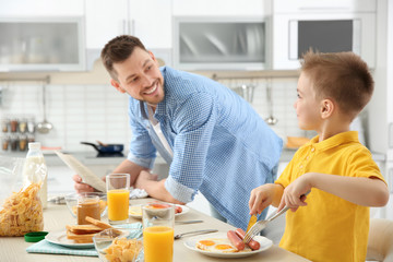 Obraz na płótnie Canvas Dad and son having lunch at home