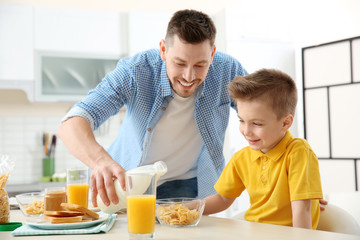 Obraz na płótnie Canvas Dad and son having lunch at home