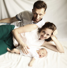 family happiness concept - happy mother and father lie side by s
