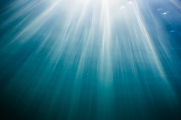 Sun rays in underwater. Ocean pattern in water. Ocean texture