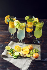 Set lemonade with ice in glass hurricane with tropical fruits