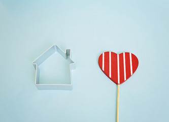Small house and red heart on a blue background. Dream house and mortgage concept. Home sweet home
