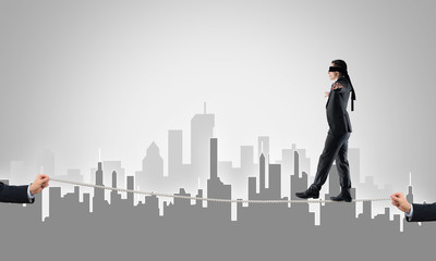 Fototapeta premium Business concept of risk support and assistance with man balancing on rope
