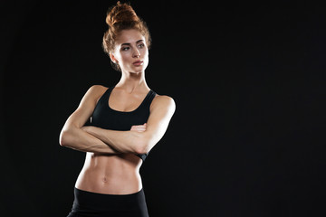 Obraz premium Serious young sports lady posing with arms crossed