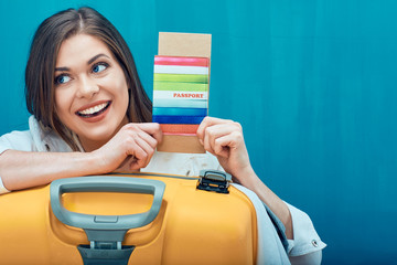 Smiling woman holding passport with ticket.