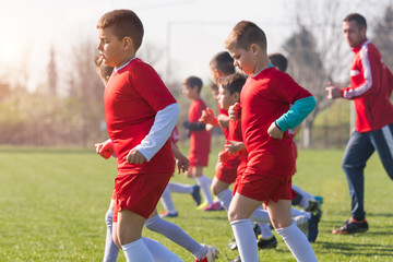 Obraz premium Kids soccer football - children players exercising before match on soccer field